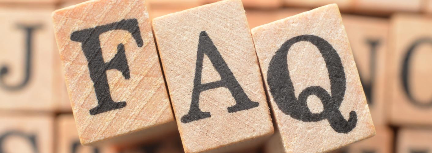 Scrabble-Buchstaben bilden das Wort FAQ.